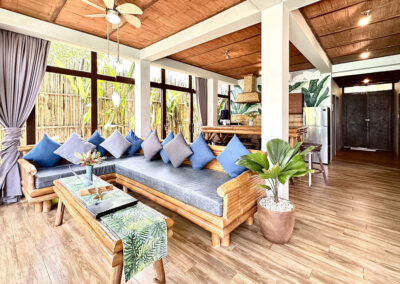 Villa living area with wooden ceiling and traditional bamboo furniture.