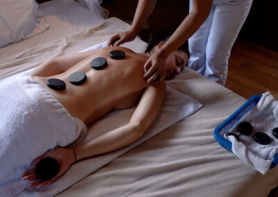 A guest relaxing with an in-room massage with hot stones.
