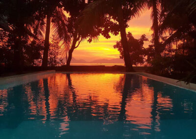 Red and orange hues of the sunset on the pool at Buko Beach Resort.