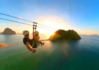 Zip lining at sunset with view of small island in El Nido, Philippines.